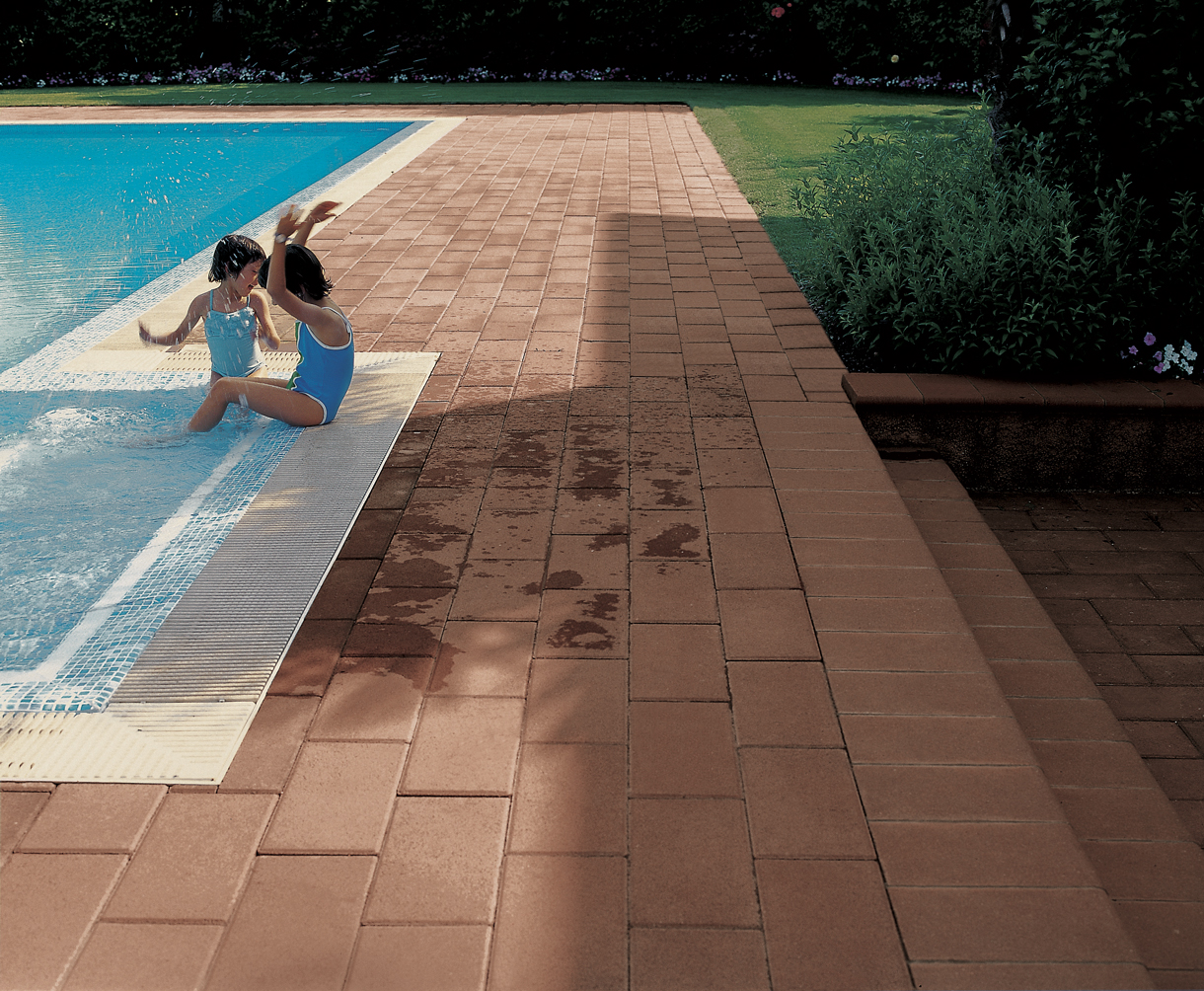 Pavimento realizzato con il prodotto Alba, finitura Quarzo e colore Terra di Siena, ambientato al bordo piscina